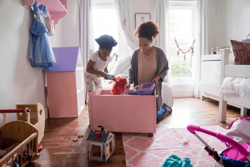 a mother helping her daughter sort her toys.