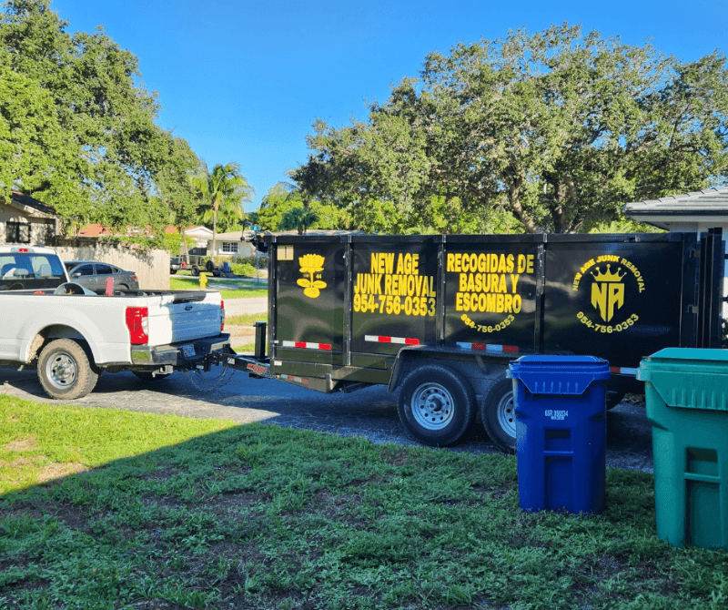 new age junk removal & hauling truck outside a house.